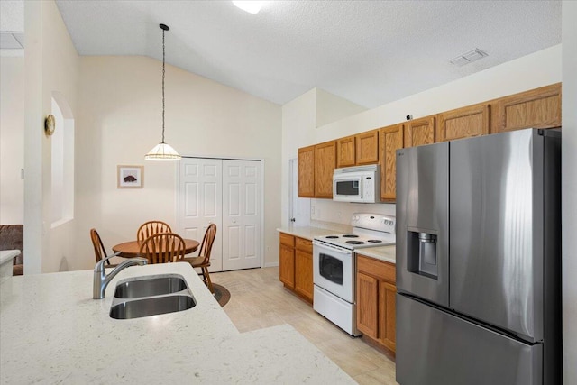 516 SW Crawfish Dr, Port Saint Lucie, FL 34953 - kitchen featuring white appliances, vaulted ceiling, brown cabinets, decorative light fixtures, and light stone counters