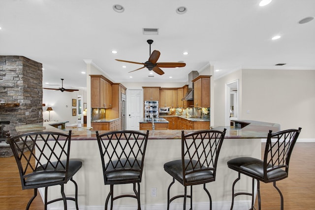11085 86th St N, Palm Beach Gardens, FL 33412 - kitchen with ceiling fan, recessed lighting, light wood-style flooring, a breakfast bar area, and crown molding