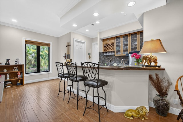 11085 86th St N, Palm Beach Gardens, FL 33412 - indoor wet bar with ornamental molding, wood finished floors, decorative backsplash, and recessed lighting