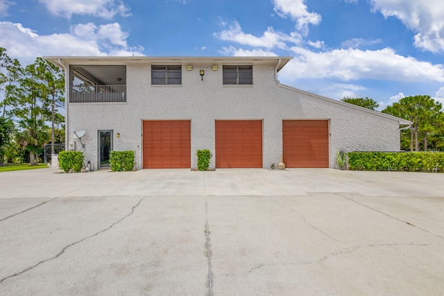 11085 86th St N, Palm Beach Gardens, FL 33412 - view of front of home with driveway, an attached garage, a balcony, and stucco siding