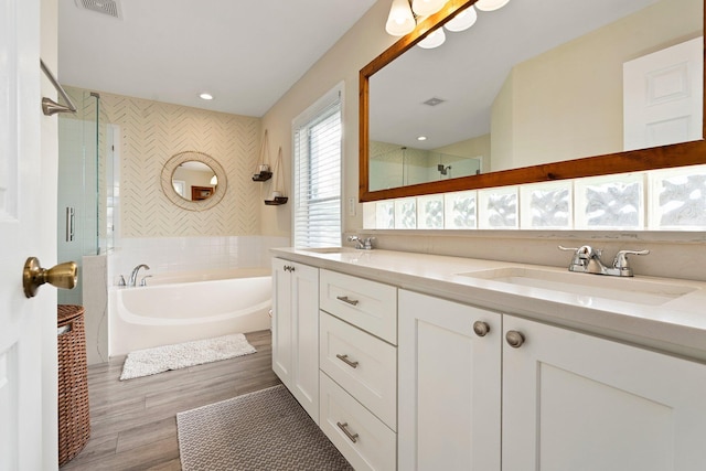 6351 Adams St, Jupiter, FL 33458 - full bath with a garden tub, double vanity, a tile shower, and wood finished floors