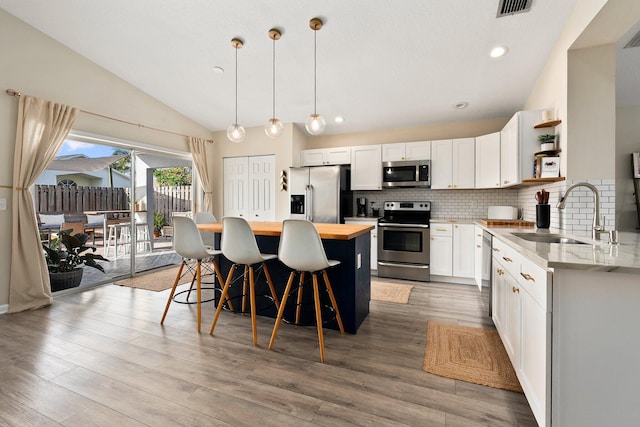6351 Adams St, Jupiter, FL 33458 - kitchen with stainless steel appliances, wooden counters, open shelves, vaulted ceiling, and a center island