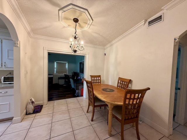 1114 SW Del Rio Blvd, Port Saint Lucie, FL 34953 - dining room featuring arched walkways, light tile patterned floors, ornamental molding, and a textured ceiling