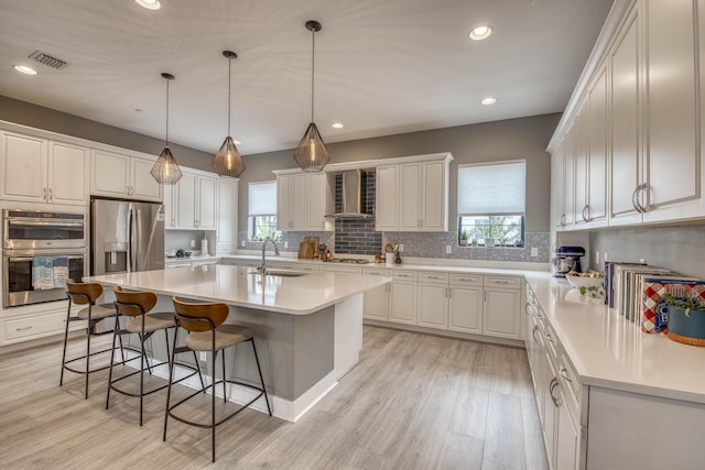 5178 Beckman Ter, Palm Beach Gardens, FL 33418 - kitchen with stainless steel appliances, a kitchen breakfast bar, healthy amount of natural light, light wood-style floors, and recessed lighting