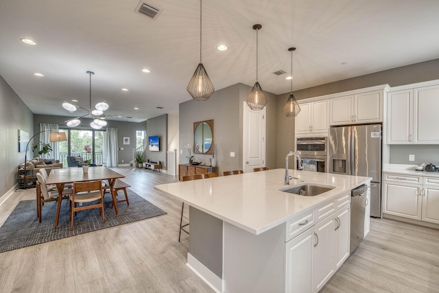 5178 Beckman Ter, Palm Beach Gardens, FL 33418 - kitchen with open floor plan, stainless steel appliances, light wood-type flooring, white cabinetry, and light countertops