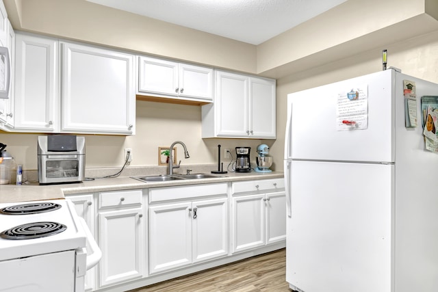 1395 SE Darling St, Stuart, FL 34997 - kitchen featuring white appliances, light countertops, white cabinetry, and light wood-style floors