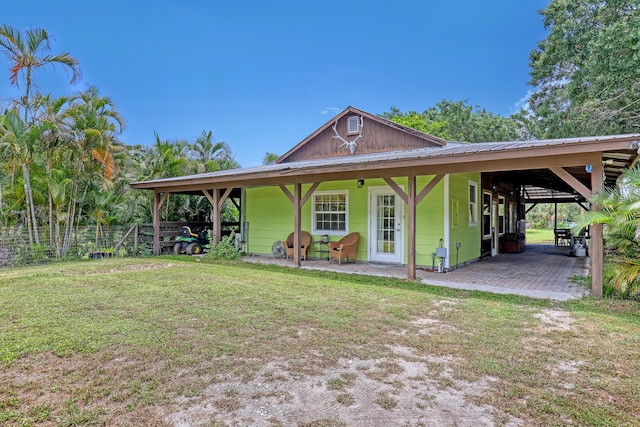 1395 SE Darling St, Stuart, FL 34997 - view of front of house with a metal roof and a patio area