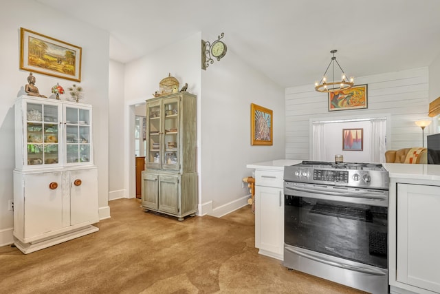 1395 SE Darling St, Stuart, FL 34997 - kitchen featuring stainless steel range oven, a chandelier, light countertops, light colored carpet, and wood walls