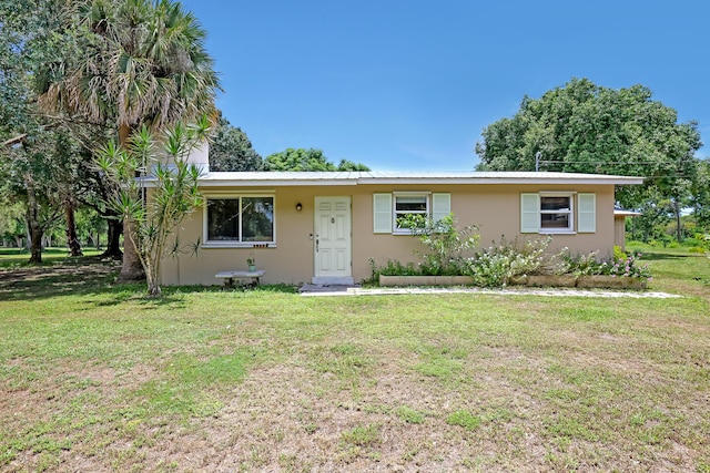 1395 SE Darling St, Stuart, FL 34997 - ranch-style house featuring stucco siding, a front lawn, and a metal roof