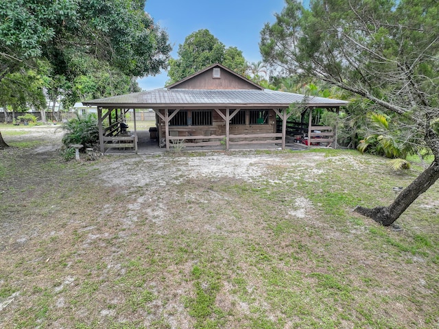 1395 SE Darling St, Stuart, FL 34997 - view of front of house with a metal roof, an exterior structure, and an outbuilding