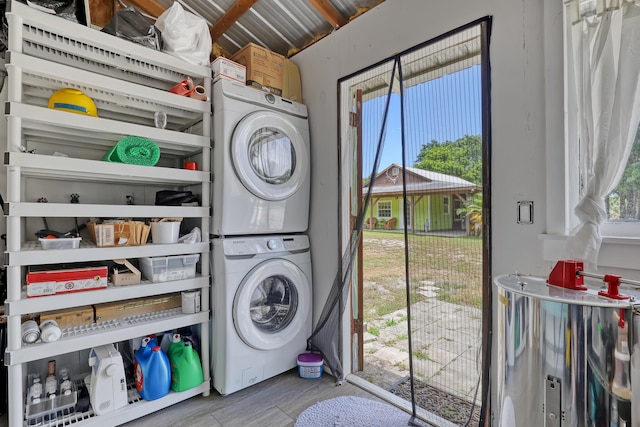 1395 SE Darling St, Stuart, FL 34997 - laundry room with stacked washing machine and dryer, wood finished floors, and healthy amount of natural light