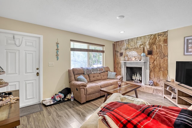 1395 SE Darling St, Stuart, FL 34997 - living room with wood finished floors, a stone fireplace, a textured ceiling, and recessed lighting
