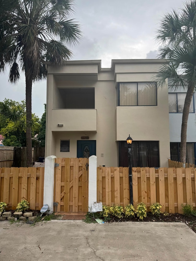 12718 Peconic Ct, Wellington, FL 33414 - view of front of house with stucco siding, a fenced front yard, and a gate