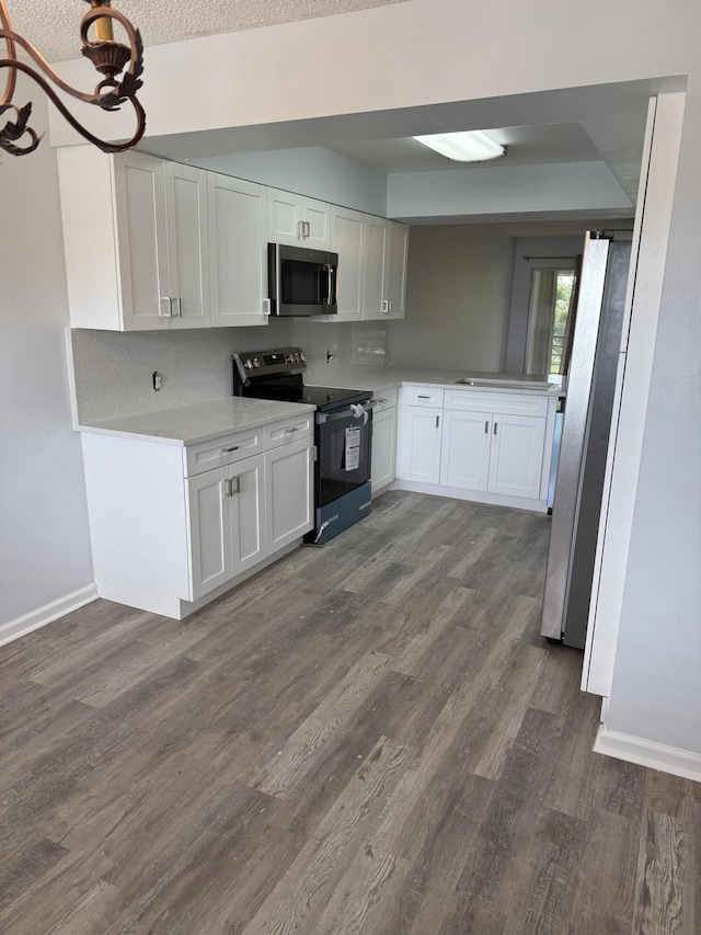 3111 Gardens E Dr Unit 31, Palm Beach Gardens, FL 33410 - kitchen featuring appliances with stainless steel finishes, dark wood-style floors, white cabinetry, light countertops, and a textured ceiling