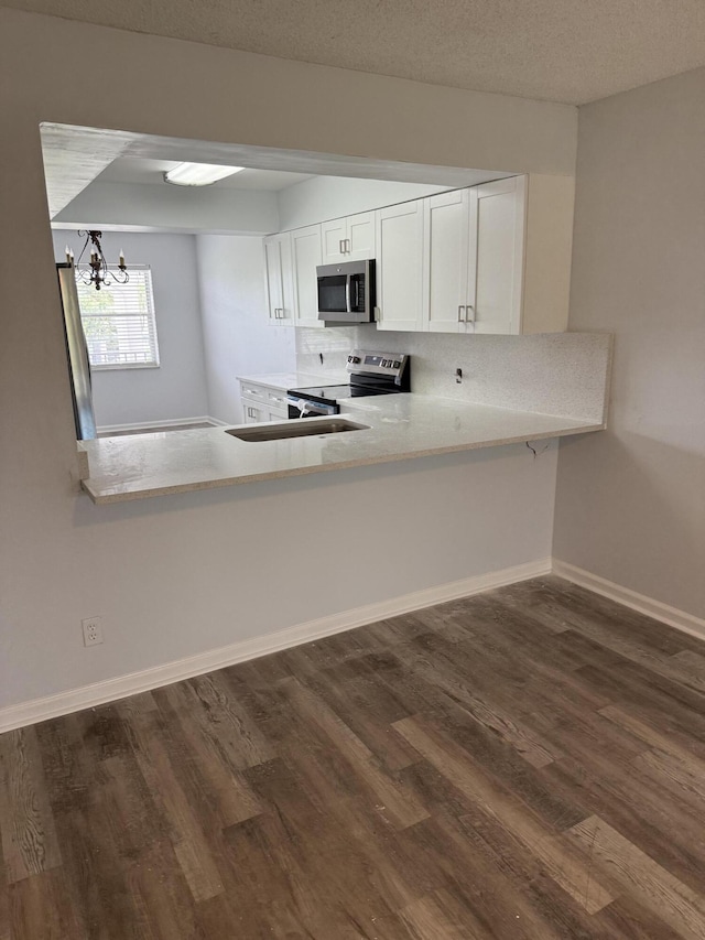 3111 Gardens E Dr Unit 31, Palm Beach Gardens, FL 33410 - kitchen featuring stainless steel appliances, dark wood-style flooring, light countertops, white cabinets, and a chandelier