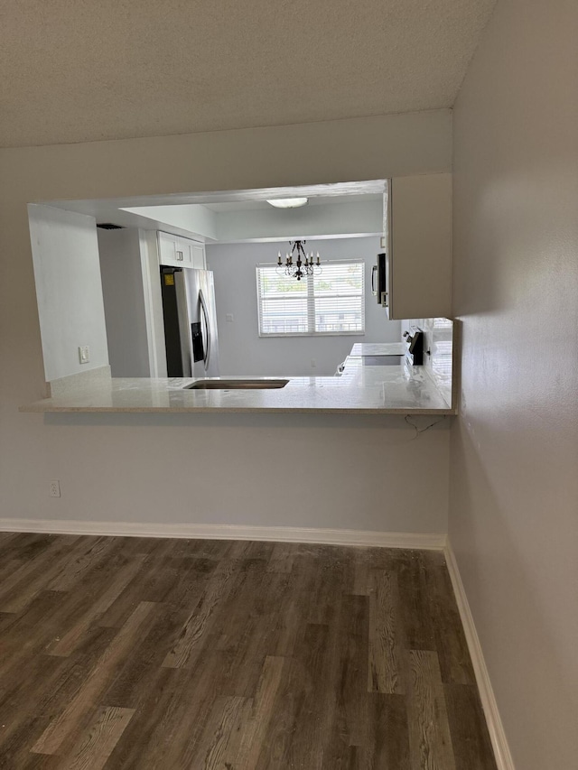 3111 Gardens E Dr Unit 31, Palm Beach Gardens, FL 33410 - kitchen with stainless steel fridge, a chandelier, dark wood-style flooring, white cabinets, and light countertops