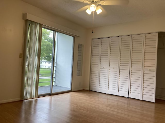 353 Mansfield I Unit 353I, Boca Raton, FL 33434 - unfurnished bedroom featuring access to exterior, wood finished floors, a closet, and ceiling fan