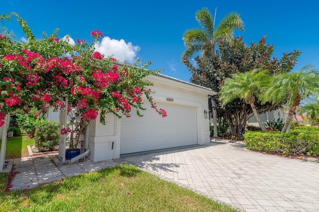 1513 SE Holyrood Ln, Port Saint Lucie, FL 34952 - view of front of home featuring a garage, decorative driveway, and stucco siding