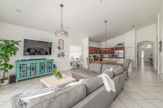 1513 SE Holyrood Ln, Port Saint Lucie, FL 34952 - living room with a chandelier, light tile patterned floors, high vaulted ceiling, and arched walkways