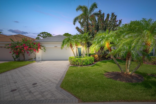 1513 SE Holyrood Ln, Port Saint Lucie, FL 34952 - view of front of home with a garage, decorative driveway, a front yard, and stucco siding