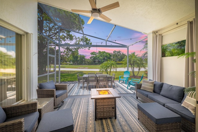 1513 SE Holyrood Ln, Port Saint Lucie, FL 34952 - deck at dusk with an outdoor living space with a fire pit, outdoor dining area, glass enclosure, and a ceiling fan