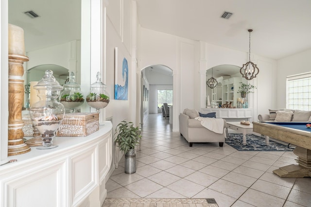 1513 SE Holyrood Ln, Port Saint Lucie, FL 34952 - living room featuring arched walkways, light tile patterned flooring, and a chandelier