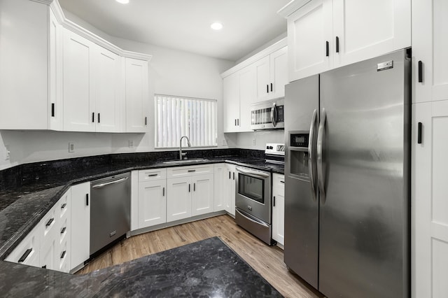 5711 NW 125th Ave, Coral Springs, FL 33076 - kitchen featuring stainless steel appliances, light wood-type flooring, white cabinetry, recessed lighting, and dark stone counters