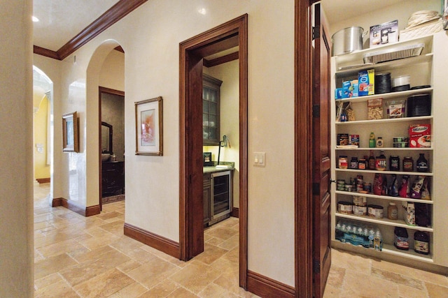 3870 NE 31st Ave, Lighthouse Point, FL 33064 - corridor featuring ornamental molding, arched walkways, wine cooler, and stone tile flooring