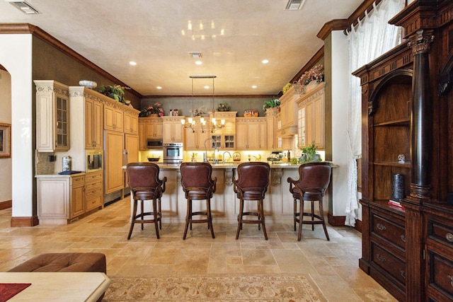 3870 NE 31st Ave, Lighthouse Point, FL 33064 - kitchen featuring a chandelier, stone tile floors, glass insert cabinets, appliances with stainless steel finishes, and ornamental molding