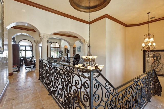 3870 NE 31st Ave, Lighthouse Point, FL 33064 - hallway featuring a chandelier, arched walkways, stone tile floors, decorative columns, and an upstairs landing