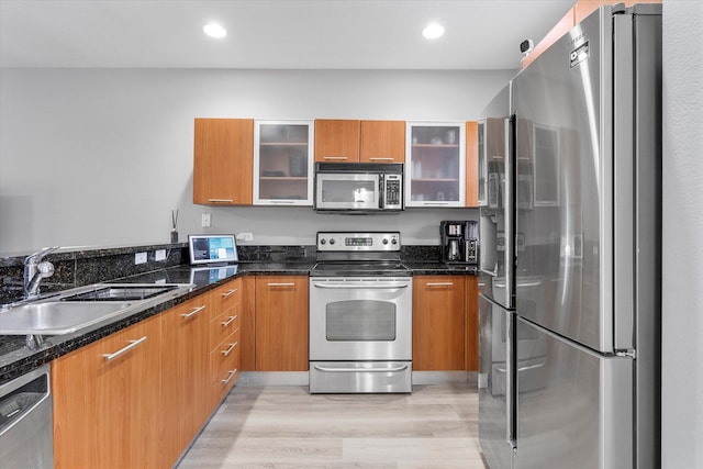 2536 SW 14th Ave Unit 1102, Fort Lauderdale, FL 33315 - kitchen featuring stainless steel appliances, light wood-type flooring, brown cabinetry, dark stone countertops, and recessed lighting