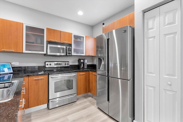 2536 SW 14th Ave Unit 1102, Fort Lauderdale, FL 33315 - kitchen with appliances with stainless steel finishes, brown cabinets, light wood-style floors, dark stone countertops, and recessed lighting