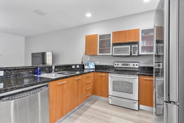 2536 SW 14th Ave Unit 1102, Fort Lauderdale, FL 33315 - kitchen featuring appliances with stainless steel finishes, light wood-style floors, dark stone counters, brown cabinetry, and recessed lighting