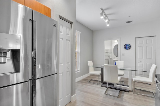 2536 SW 14th Ave Unit 1102, Fort Lauderdale, FL 33315 - dining room with stacked washing machine and dryer, light wood-style flooring, and track lighting