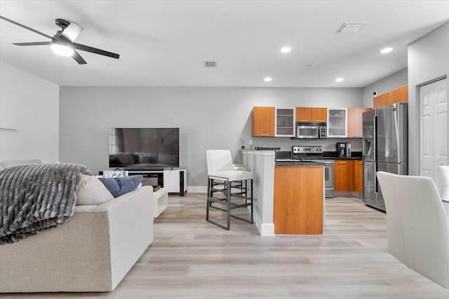 2536 SW 14th Ave Unit 1102, Fort Lauderdale, FL 33315 - kitchen featuring appliances with stainless steel finishes, brown cabinetry, a breakfast bar, a peninsula, and open floor plan