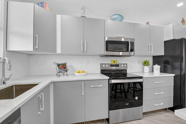 930 Osceola Dr Unit 8, Boca Raton, FL 33432 - kitchen featuring stainless steel appliances, gray cabinets, light stone countertops, and light wood finished floors