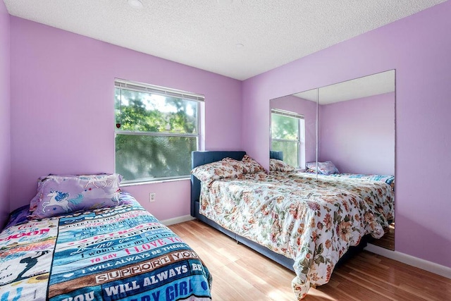 1530 Cypress Way Unit E, Palm Springs, FL 33406 - bedroom featuring wood finished floors and a textured ceiling