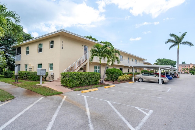 2950 SE Ocean Blvd Unit 119-6, Stuart, FL 34996 - view of property featuring covered and uncovered parking and stairs