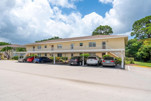 2950 SE Ocean Blvd Unit 119-6, Stuart, FL 34996 - view of building exterior featuring covered and uncovered parking and stairway