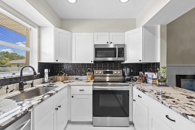 2950 SE Ocean Blvd Unit 119-6, Stuart, FL 34996 - kitchen featuring appliances with stainless steel finishes, light stone counters, white cabinetry, decorative backsplash, and recessed lighting
