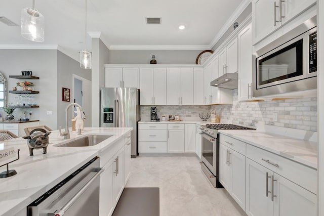 572 SE Villandry Way, Port Saint Lucie, FL 34984 - kitchen featuring appliances with stainless steel finishes, ventilation hood, ornamental molding, white cabinetry, and decorative light fixtures