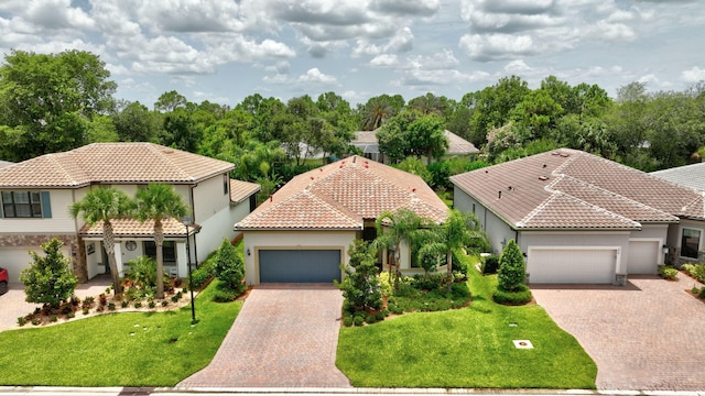 572 SE Villandry Way, Port Saint Lucie, FL 34984 - mediterranean / spanish-style home with an attached garage, stucco siding, decorative driveway, and a tiled roof