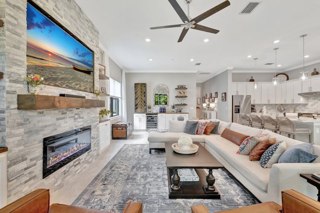 572 SE Villandry Way, Port Saint Lucie, FL 34984 - living room featuring ceiling fan, crown molding, a large fireplace, recessed lighting, and beverage cooler