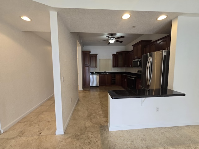 1620 Presidential Way Unit 106, West Palm Beach, FL 33401 - kitchen with appliances with stainless steel finishes, dark countertops, a peninsula, dark brown cabinets, and a ceiling fan