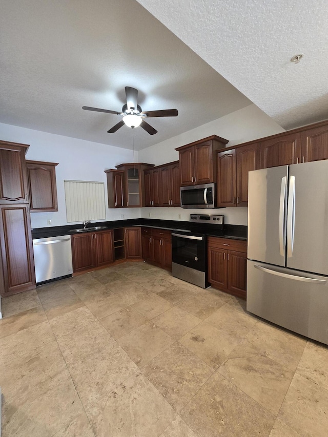 1620 Presidential Way Unit 106, West Palm Beach, FL 33401 - kitchen with stainless steel appliances, dark countertops, ceiling fan, dark brown cabinetry, and a textured ceiling