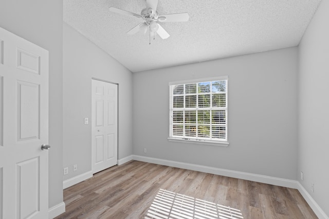 6976 Thicket Trce, Lake Worth, FL 33467 - unfurnished bedroom featuring a textured ceiling, wood finished floors, vaulted ceiling, ceiling fan, and a closet