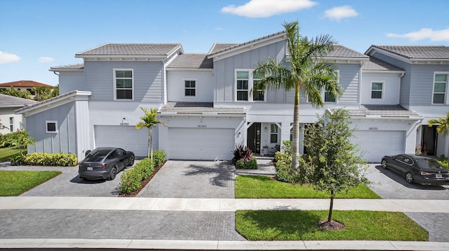 16360 Oakview Dr, Westlake, FL 33470 - view of front of property featuring board and batten siding, a garage, decorative driveway, and a tiled roof