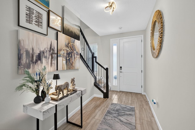 16360 Oakview Dr, Westlake, FL 33470 - entryway featuring stairs, wood finish floors, and a textured ceiling
