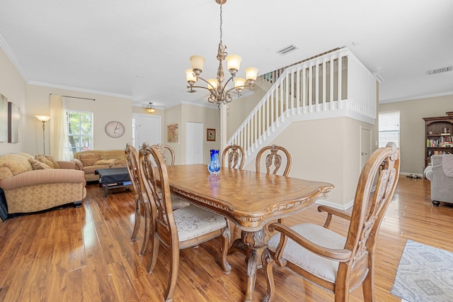 168 Canterbury Pl, Royal Palm Beach, FL 33414 - dining area featuring light wood-style flooring, a chandelier, stairway, and crown molding