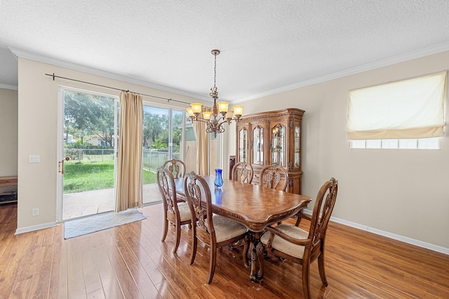 168 Canterbury Pl, Royal Palm Beach, FL 33414 - dining room with a chandelier, light wood finished floors, ornamental molding, and a textured ceiling